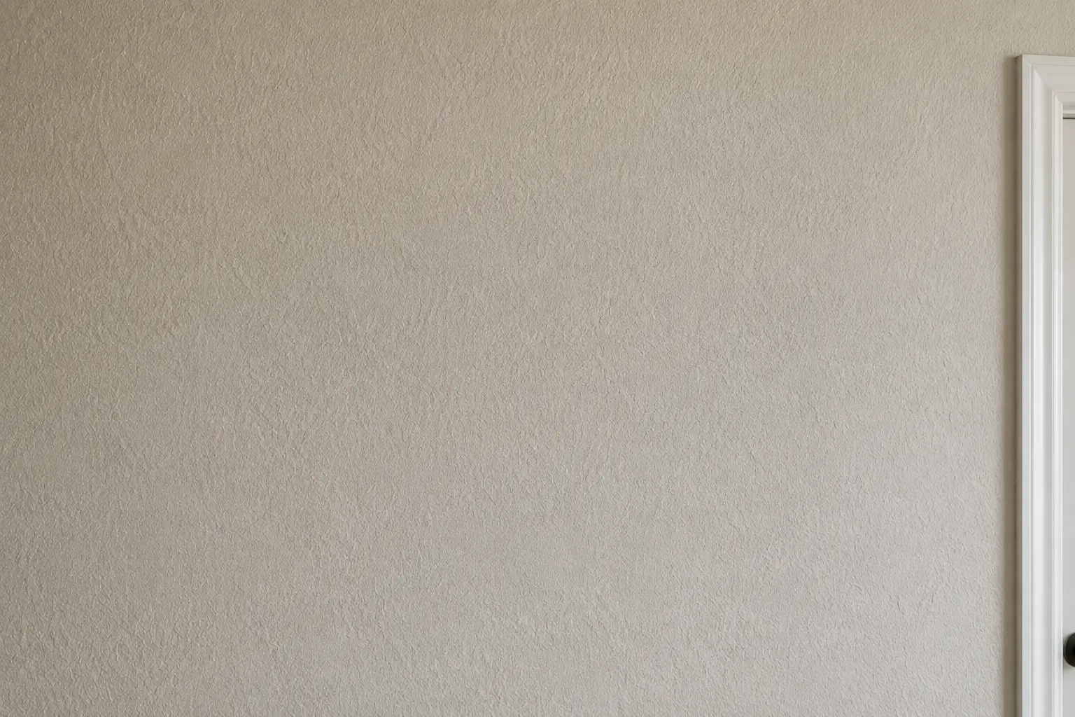 Close-up of a finished wall texture beside a door casing